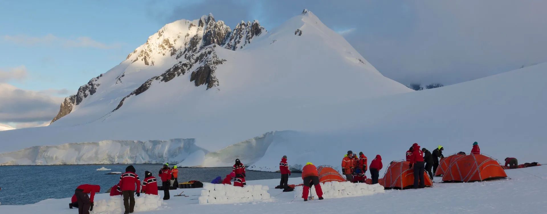 Antarctica Expedition group pitching tents on the ice