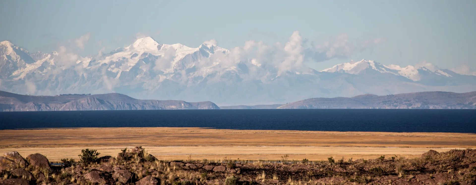 Views across Peruvian desert with snow capped mountains in the background