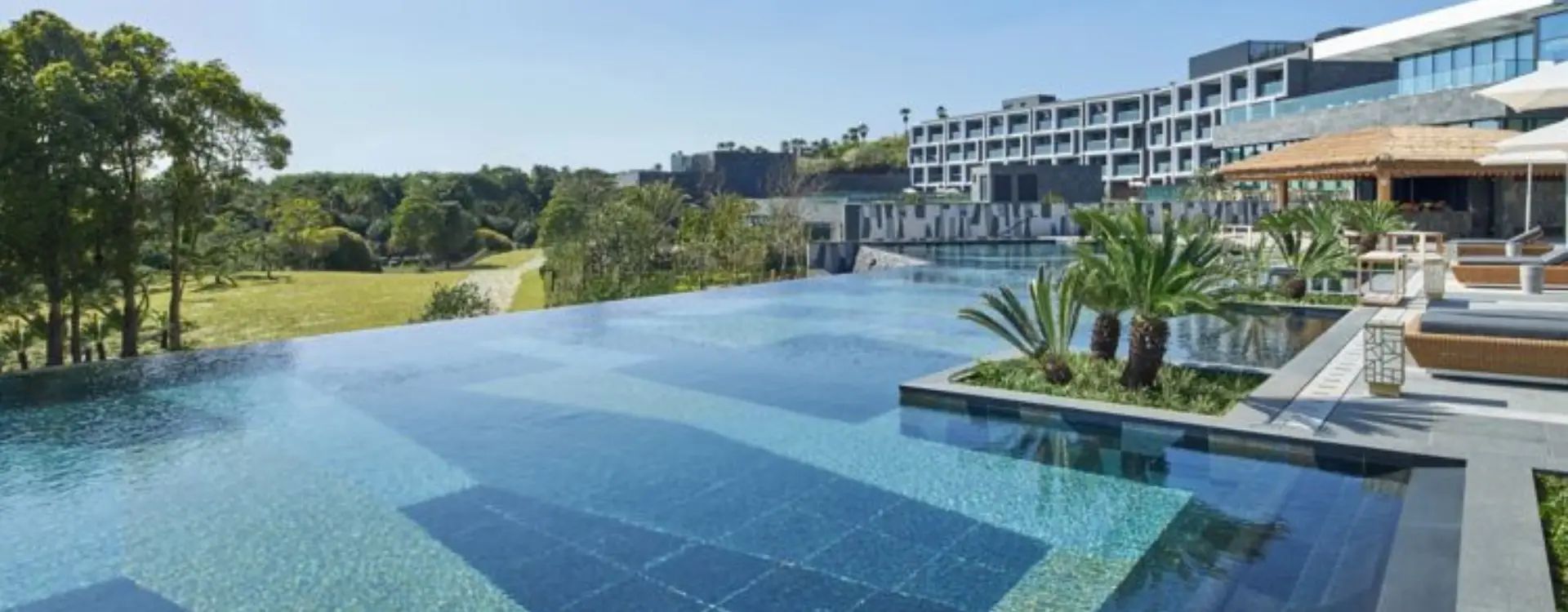 Infinity pool at luxury hotel surrounded by trees