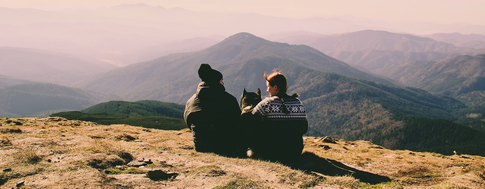 Beautiful couple in the mountains. Autumn. View from the mountain. Necking. Tourists in the hike. Husky dog travel with family