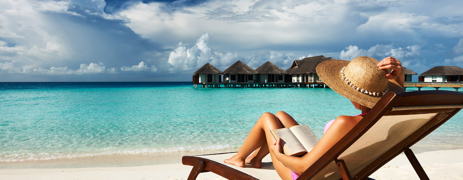 Young woman reading a book at the beach