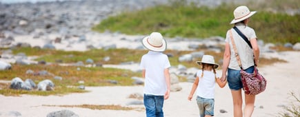 Back view of a mother and two kids hiking on Galapagos island of North Seymour