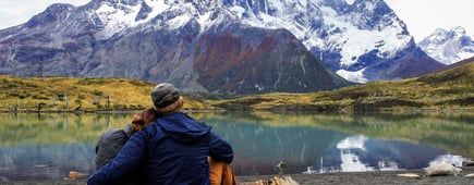 Back of couple next to beautiful mountain lake in Patagonia