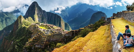 A family group observe the landscape from the platforms in Machupicchu, Peru.
