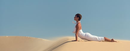 Yoga meditation on the beach, healthy female body in peace, woman sitting relaxed on sand over beautiful sea sunset