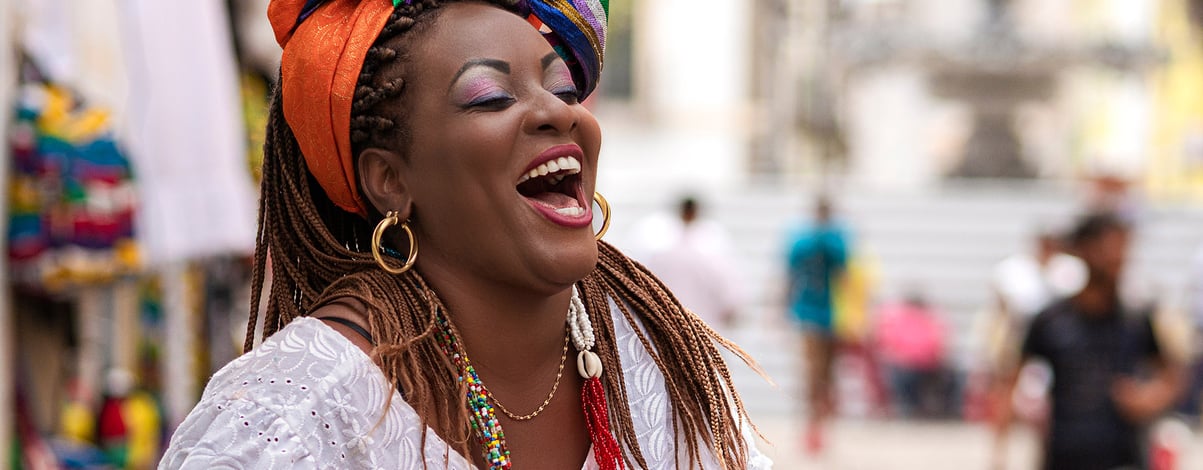 Happy Brazilian woman of African descent dressed in traditional Baiana costumes in the Historic Center of Salvador da Bahia, Brazil
