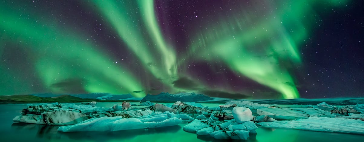 Couple watches the northern lights. Woman and man at winter night landscape . Iceland