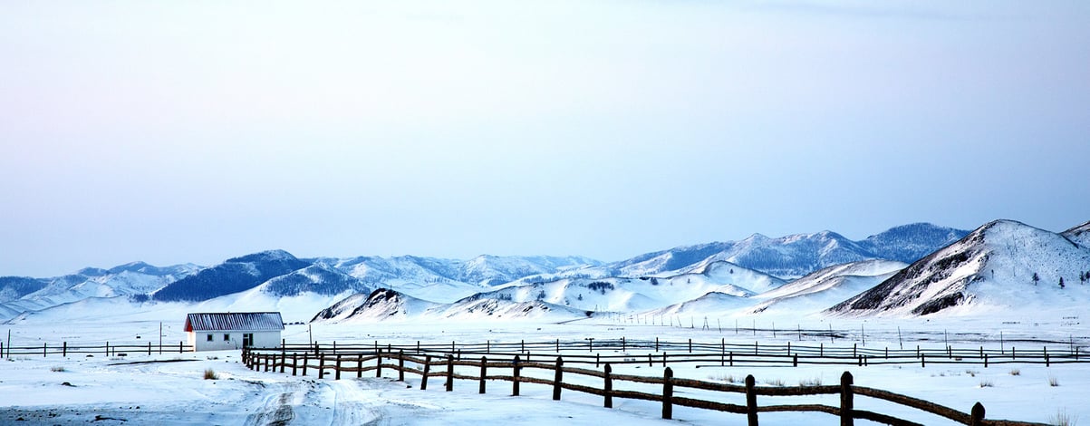 Little White House and wooden fence in a Landscape of northern Mongolia in a winter