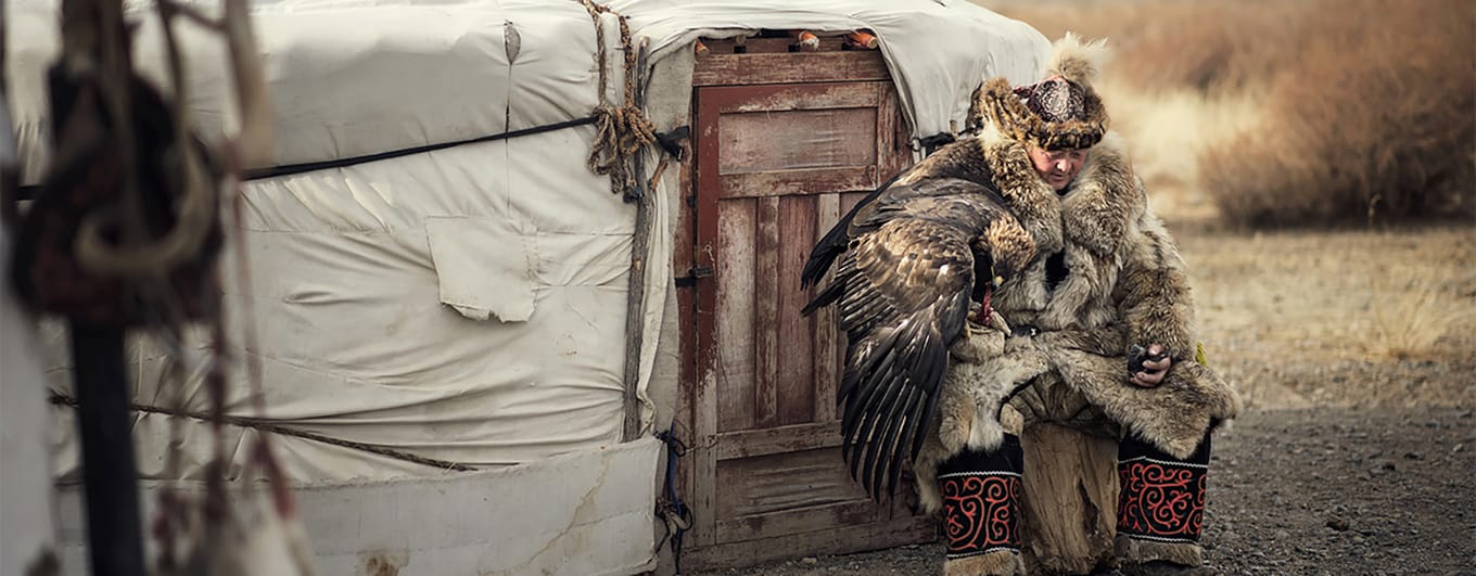 Eagle hunter stood on mountaintop in Mongolia