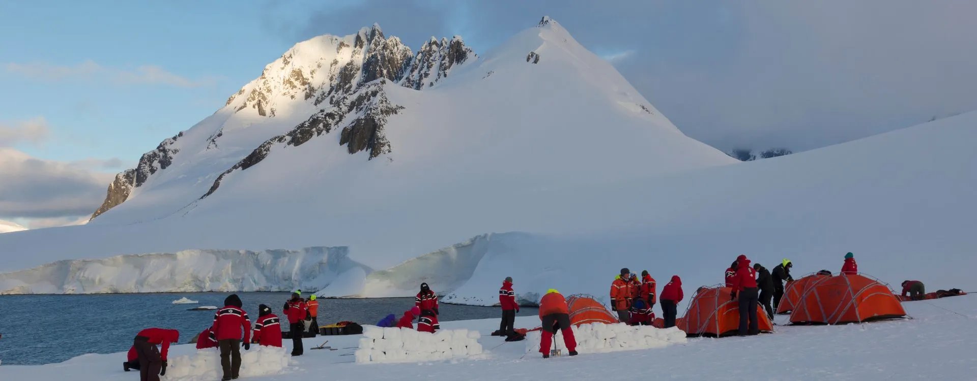 Antarctica Expedition group pitching tents on the ice