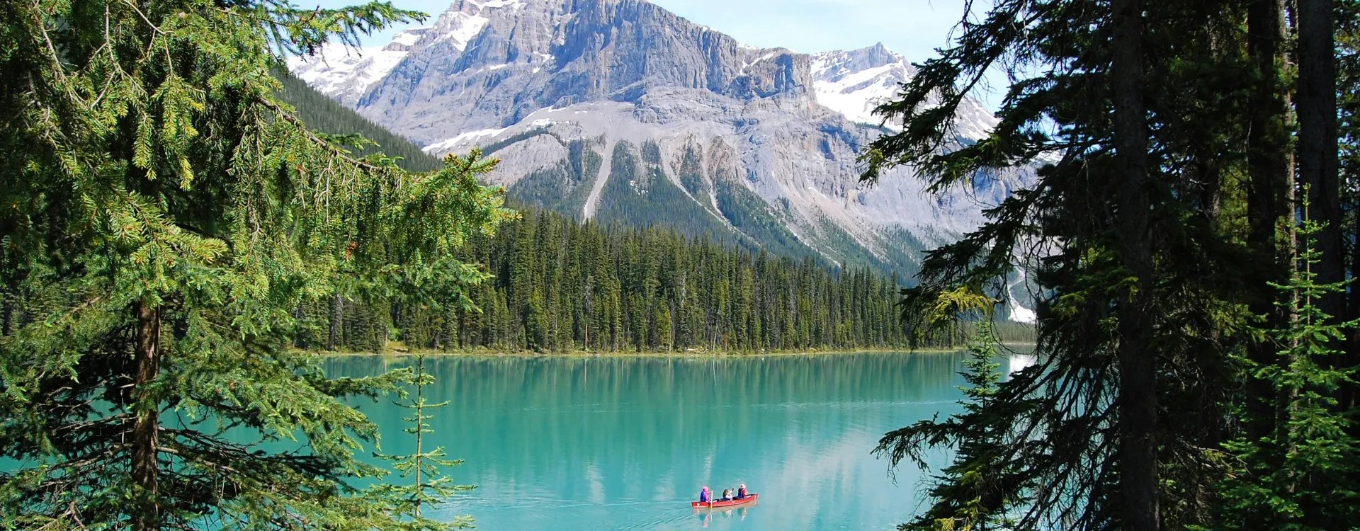 People kayaking over crystal clear blue waters in Canada