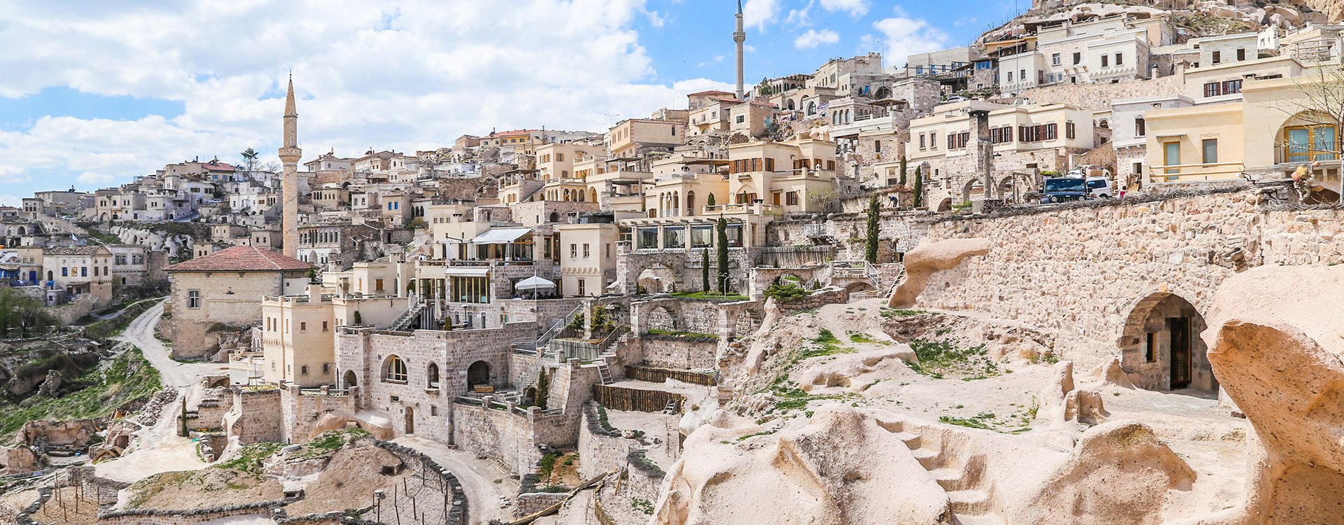 Ancient town and a castle of Uchisar dug from a mountains after sunrise, Cappadocia,