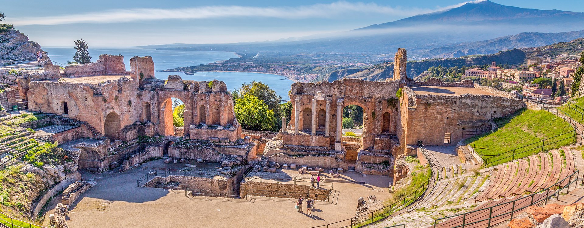 Ruins of the Ancient Greek Theater in Taormina, Italy, Sicily with the Giardini-Naxos bay of the Ionian Sea in the morning sun shine