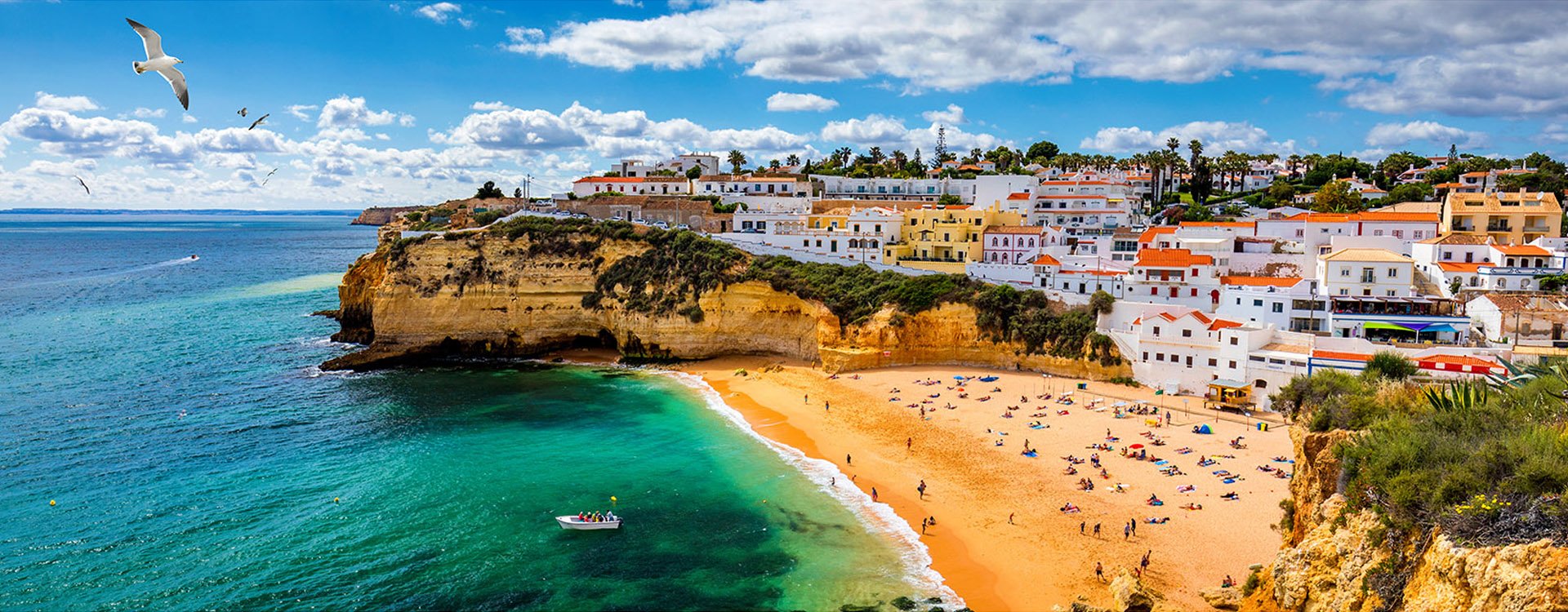 View of Carvoeiro fishing village with beautiful beach, Algarve, Portugal. View of beach in Carvoeiro town with colorful houses on coast of Portugal. The village Carvoeiro in the Algarve Portugal