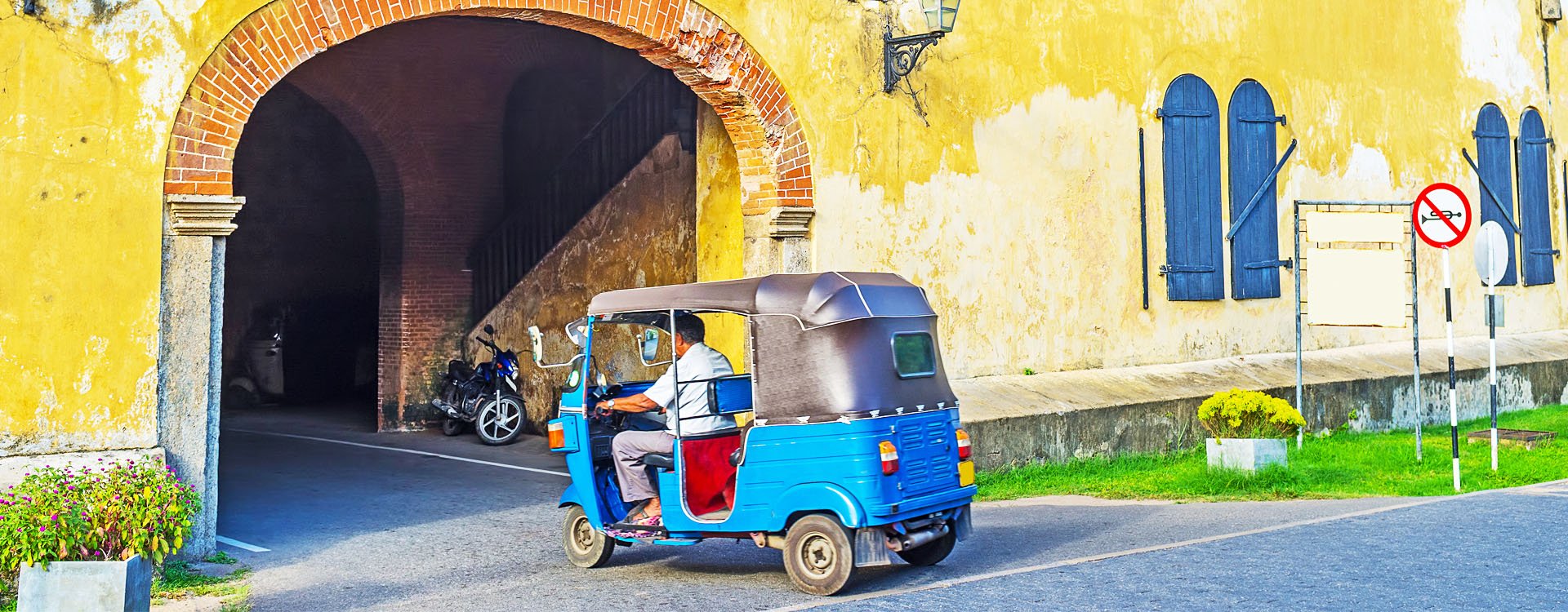 The tuk tuk riding to the exit of Galle Fort through the Old Gate, Sri Lanka.