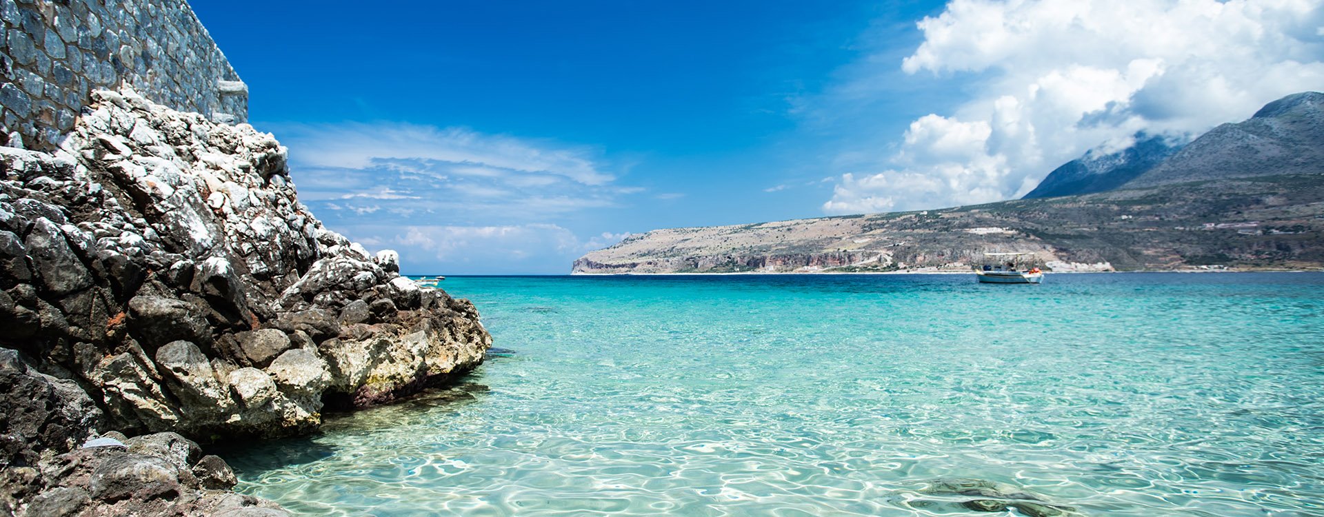 Turquoise waters of mediterranean sea with cliffs. Peloponnese, Limeni, Greece.
