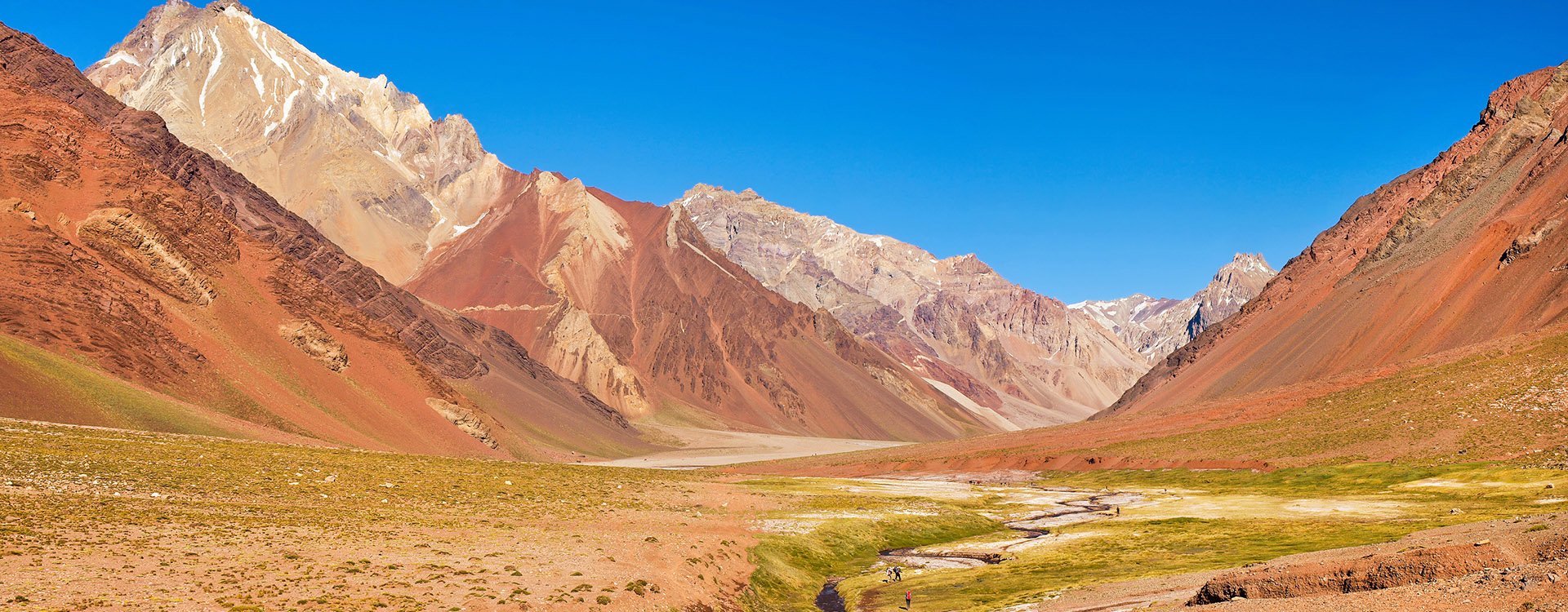 Panoramic view of mountain valley in the Andes with hikers trekking, Argentina, South America
