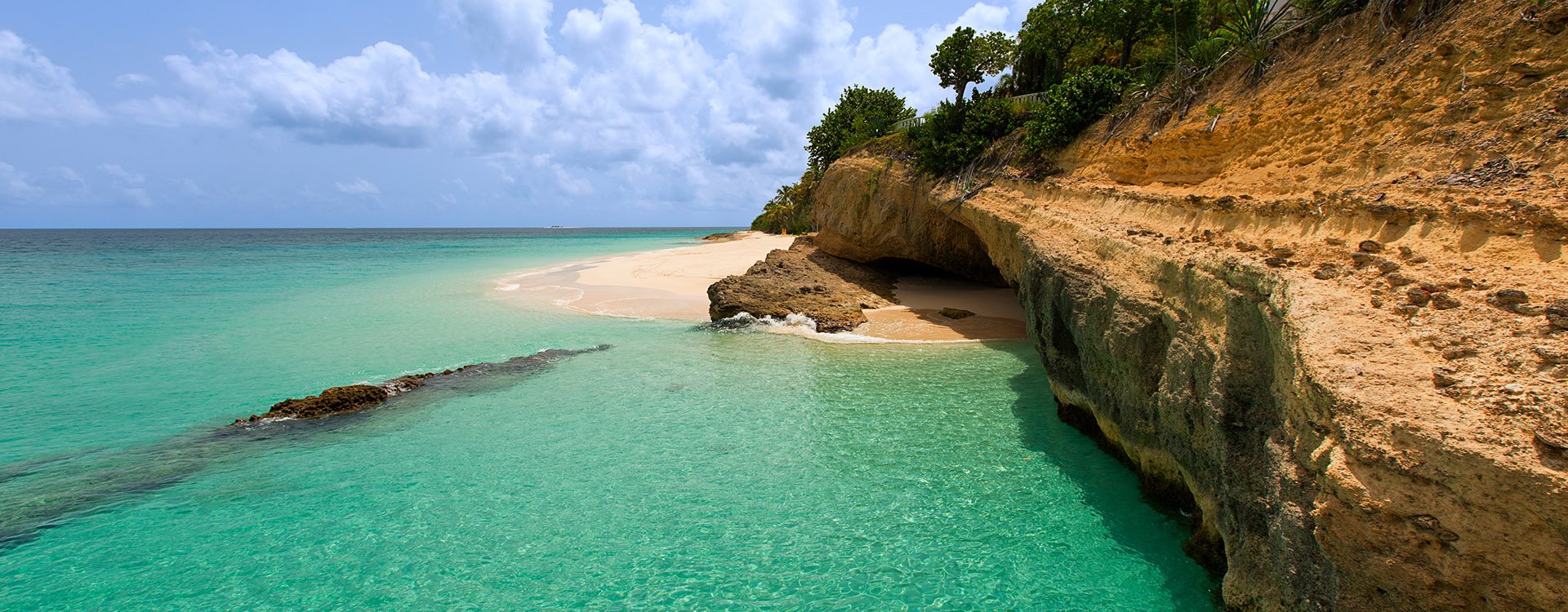 view of rugged rocky coast at anguilla island, caribbean, with turquoise water and white sand beach