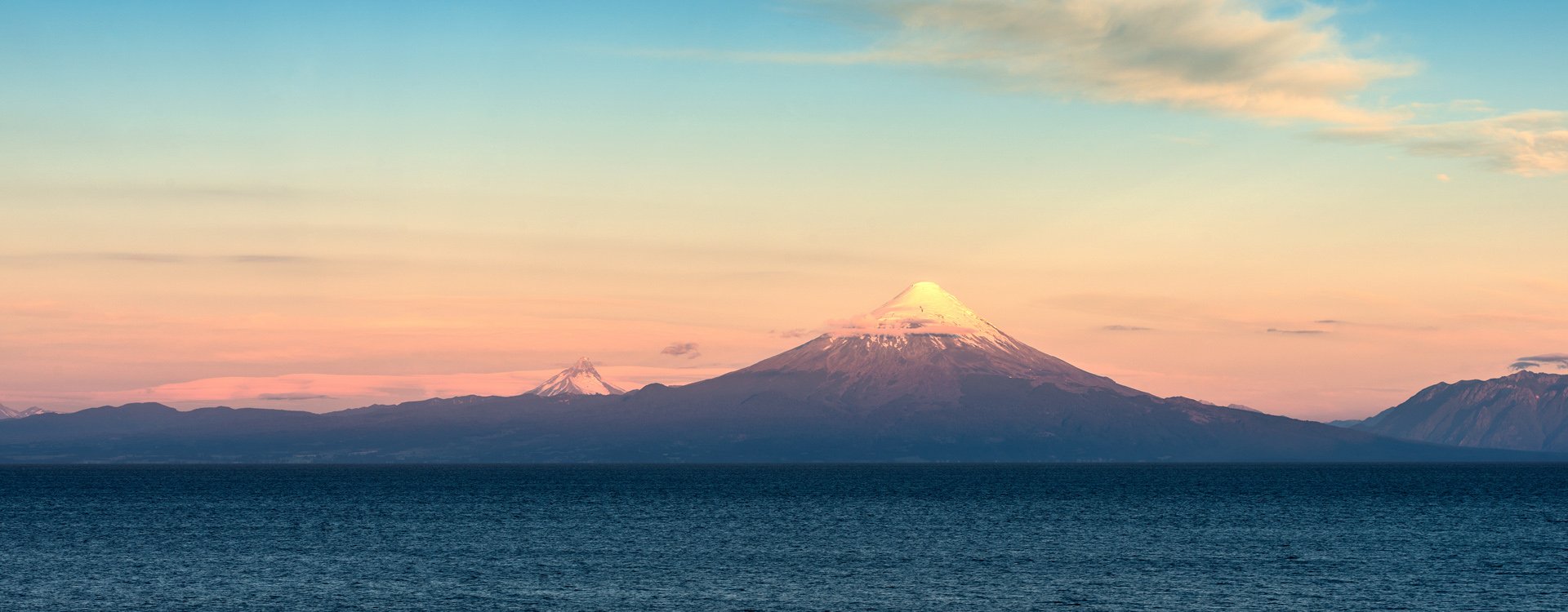 View of Osorno volcano, Puntigudo volcano and Llanquihue Lake in the Chilean Lake district at sunset