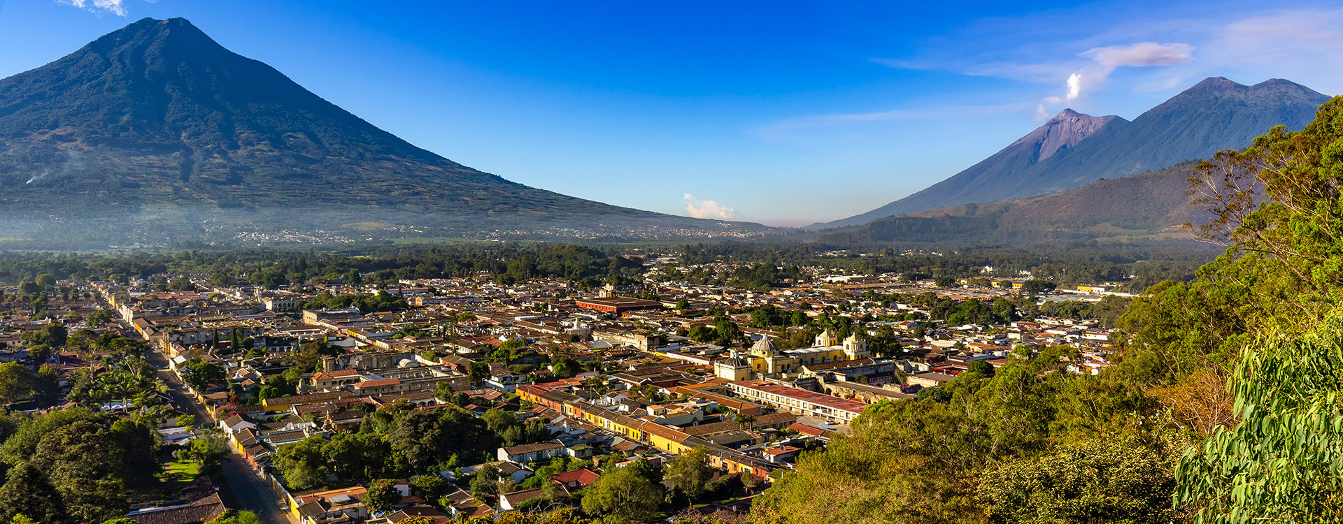 Guatemala. Antigua. Panoramic view of the city and surrounding volcanoes (from left to right): dormant Agua, smoky Fuego and Acatenango