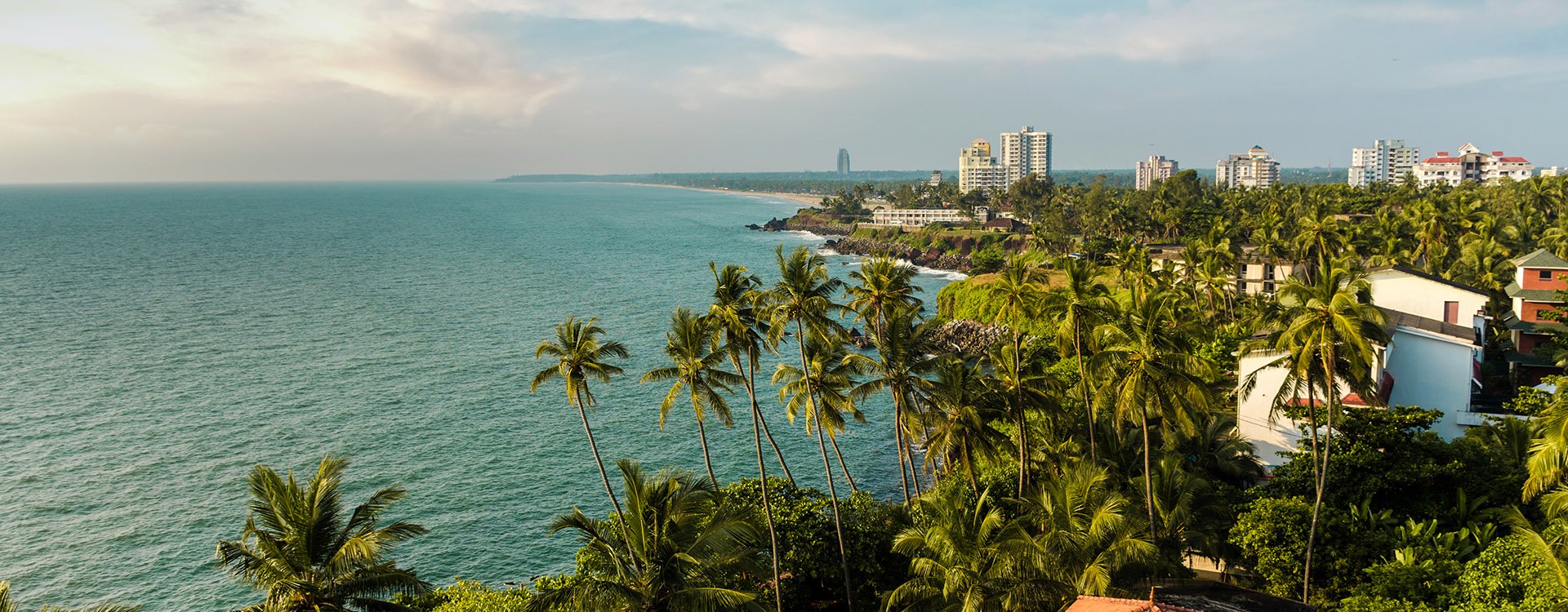 Kannur Lighthouse, Coconut trees and colorful beach with cloudy sky, Kerala