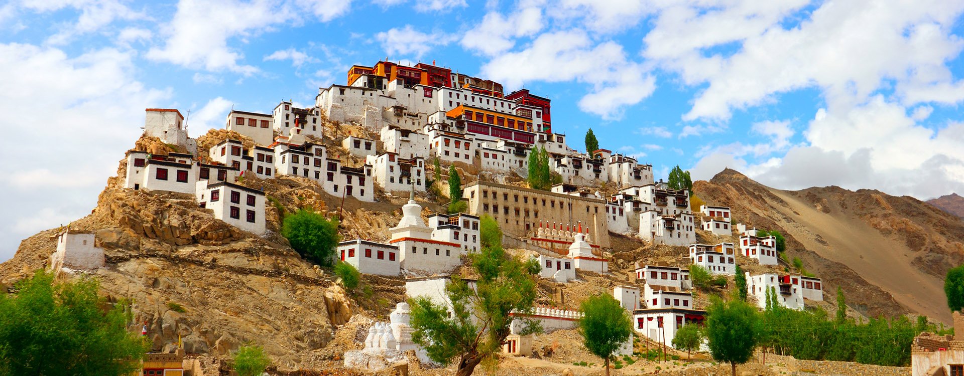 ancient Tiksey (Thiksey) Buddhist Monastery and traditional Tibetan houses against the background of blue sky - Leh district, Ladakh, Himalaya, Jammu & Kashmir, Northern India