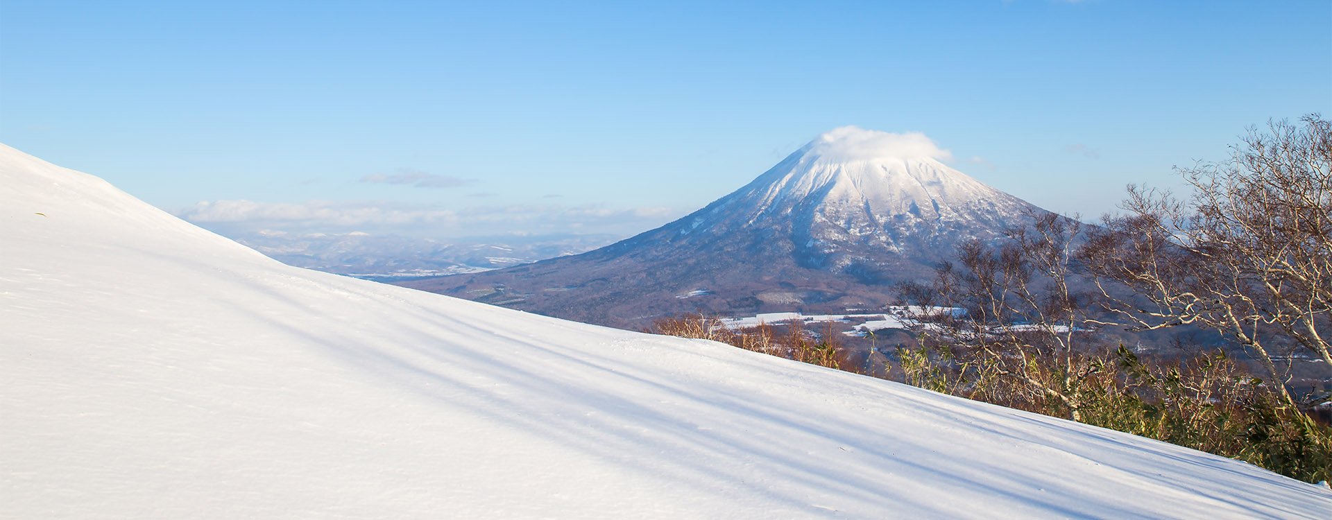 Winter Landscape of snow hill and Mt.Yotei with blue sky in Niseko, Hokkaido, Japan