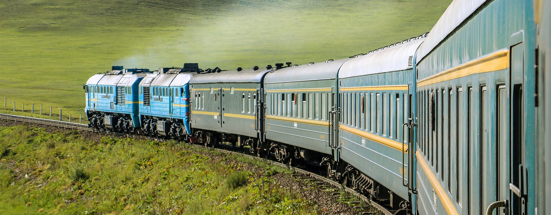 Transsiberian Railway with locomotive and steam crossing through Ulaanbaatar, Mongolia