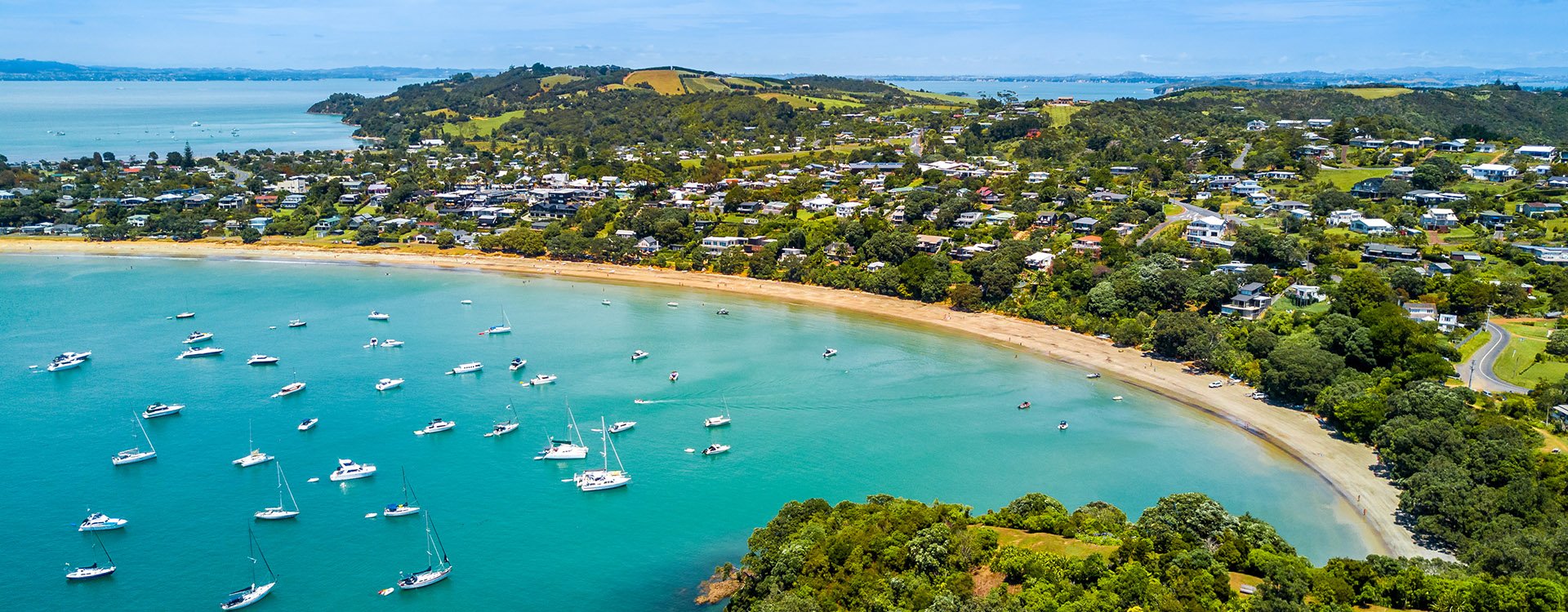 Bay at sunny day with sandy beach and residential suburbs, Waiheke Island, Auckland, New Zealand