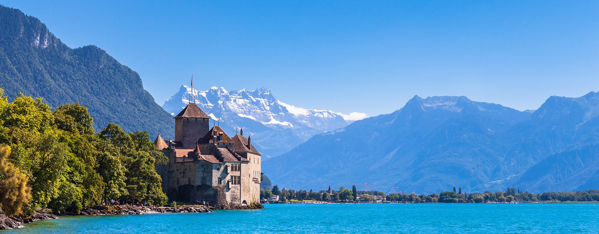 Chillon castle on the lake side of Geneva lake, with the peaks Dents du Midi of Swiss Alps in background, Montreux, Canton of Vaud, Switzerland