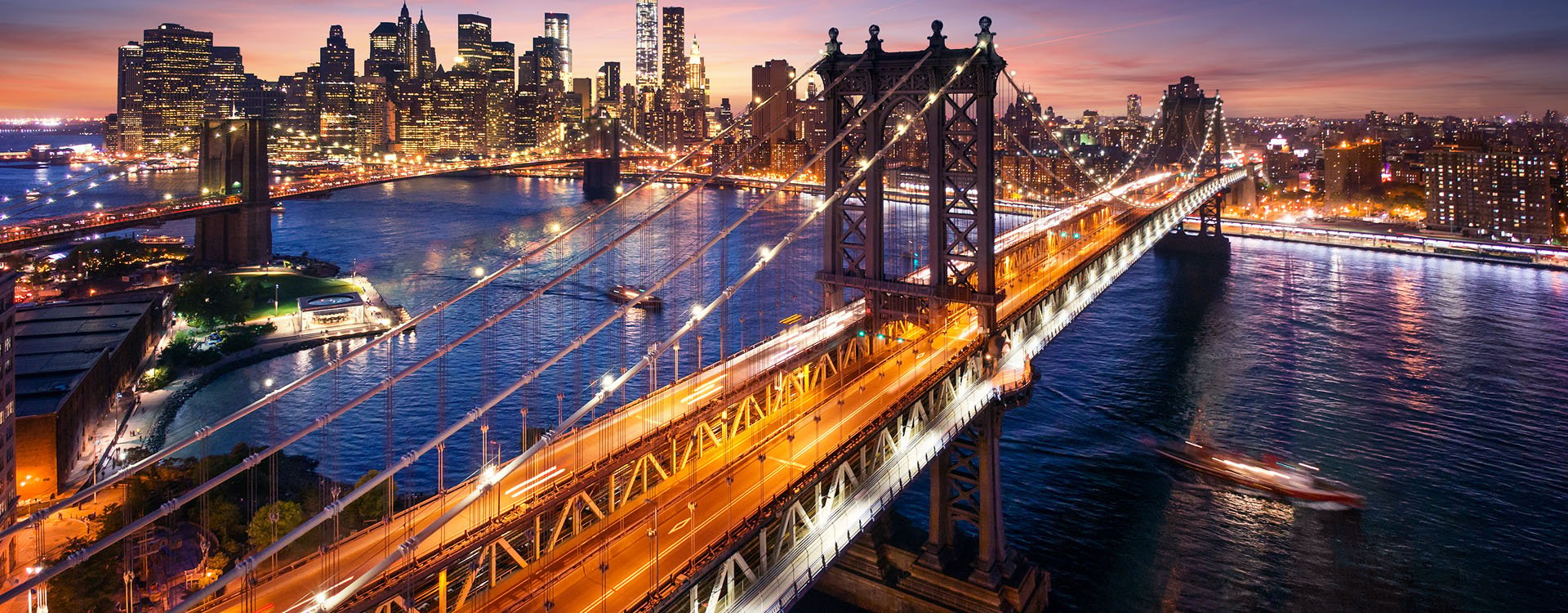 Manhattan bridge seen from a narrow alley enclosed by two brick buildings on a sunny day in summer