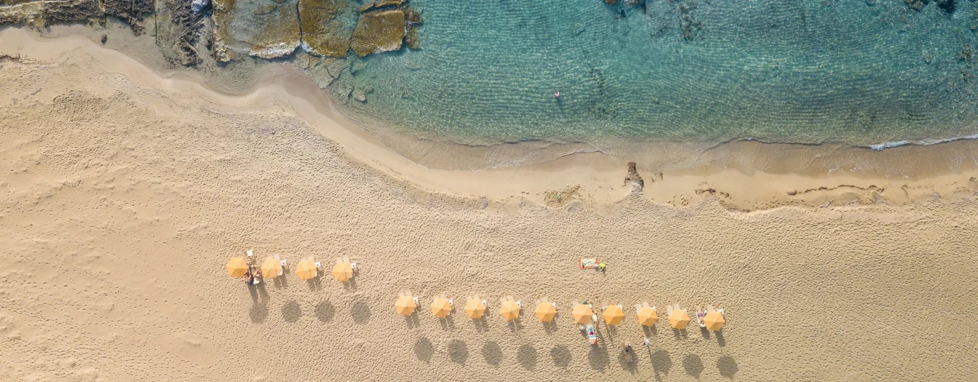 Aerial image of a beach with sun loungers and parasols in Greece