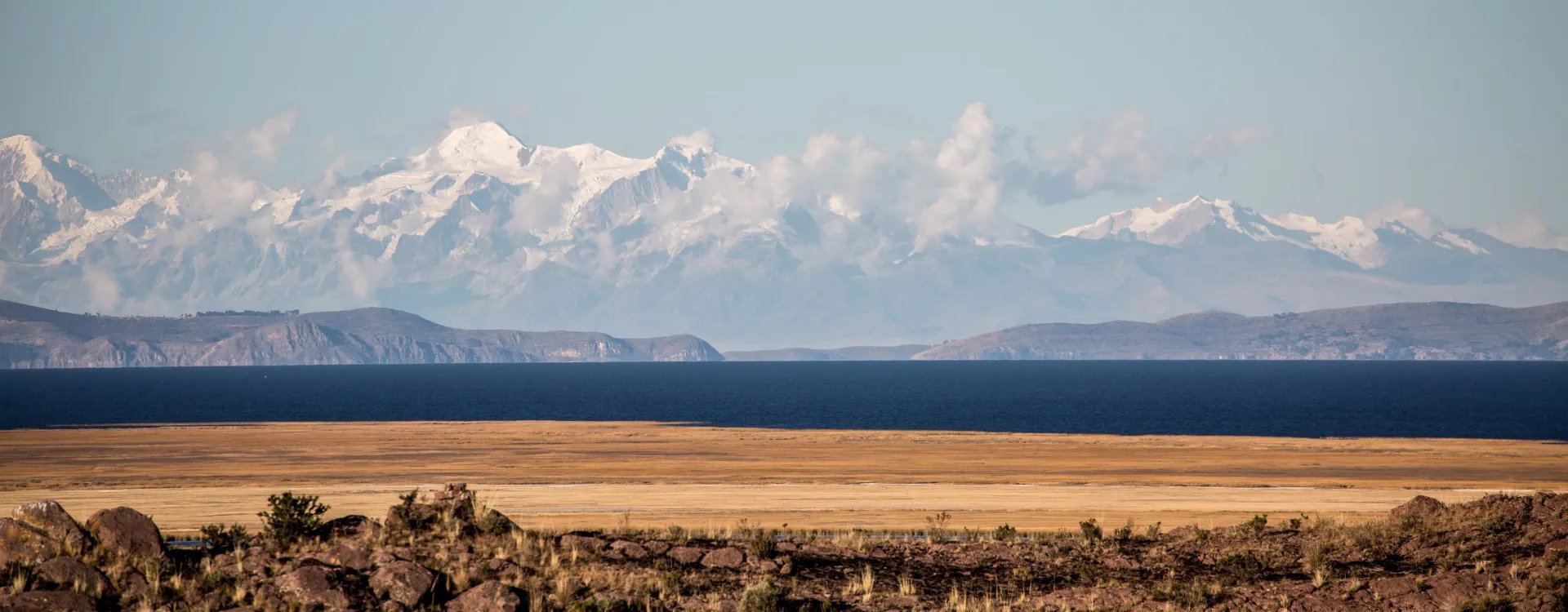 Views across Peruvian desert with snow capped mountains in the background