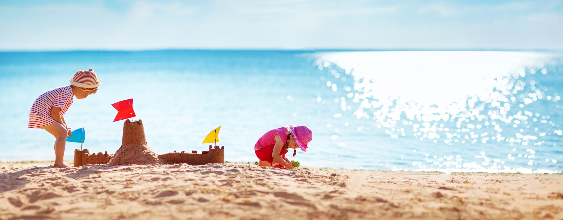 Little girl playing in outdoor swimming pool jumping into water on summer vacation on tropical beach island. luxury resort.