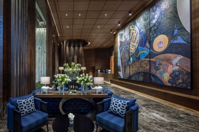 hotel lobby with artwork adorning walls and entrance table at137 pillars bangkok
