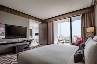 suite with king sized bed and balcony with views over bangkok at 137 pillars bangkok