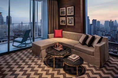 living area with sofa and balcony overlooking bangkok at 137 pillars bangkok