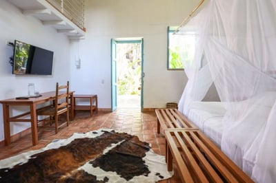 Hotel bedroom with television and door onto terrace