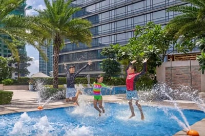 Children playing in a pool at the Shangri-La The Fort, Manila, The Philippines