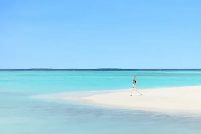 A woman practicing yoga at Heritance Aarah Maldives