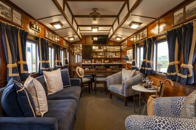 Railway carriage living area with sofas, chair and a bar