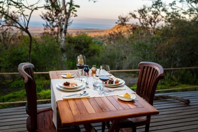 dining table on outside terrace overlooking the natural landscape with pacific ocean in the distance at galapagos safari camp