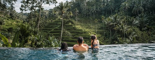 Family in an infinity pool overlooking the Tegallalang Rice Terraces in Bali, Indonesia