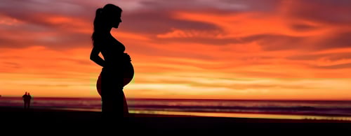 Lady enjoying the view of the ocean on her babymoon