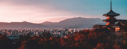 Panoramic view of Kyoto, Japan, with cityscape, mountains and a traditional pagoda, luxury holidays to Japan