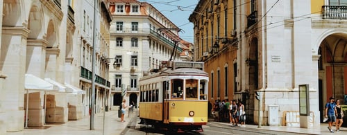 A yellow tram, called the "Elétrico 28" or Tram 28, in Lisbon, Portugal