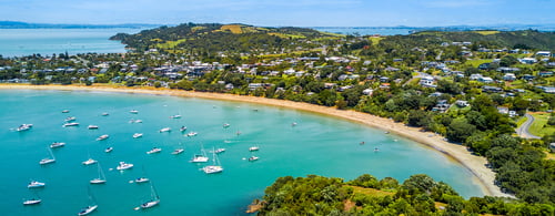 Bay at sunny day with sandy beach and residential suburbs, Waiheke Island, Auckland, New Zealand
