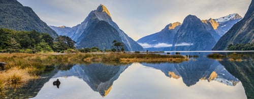 First light on Mitre Peak and surrounding mountains at Milford Sound, Fiordland, in New Zealand's South Island