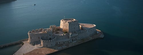 Old Grecian building surrounded by the ocean
