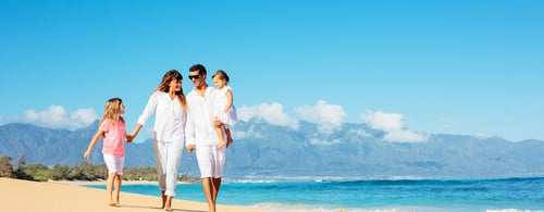 Happy family walking on the beach